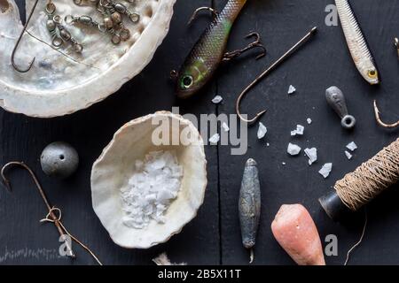 Varietà di ganci da pesca, esche, platine e conchiglie, concettuale stll vita foto aerea Foto Stock