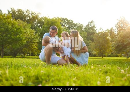 Madre padre e bambini che giocano sull'erba in natura Foto Stock