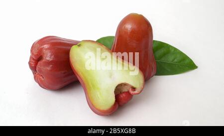 Vista ravvicinata di mele rosate intere e mezza, frutta tropicale isolata su sfondo bianco Foto Stock