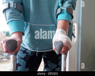 Donna ferita che cerca di camminare sulle Stampelle a casa Foto Stock