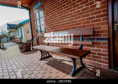 27 Wroxham, Norfolk, Regno Unito – 07 Marzo 2020. Primo piano di posti a sedere su panchina di legno sulla stazione ferroviaria di vapore di Bure Valley nel villaggio di Hoveton e Wroxh Foto Stock