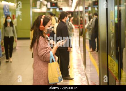 Guangzhou, Cina Guangdong Province. 9th Mar, 2020. I passeggeri attendono un treno in una stazione della metropolitana a Guangzhou, nella provincia di Guangdong della Cina meridionale, 9 marzo 2020. Il sistema metropolitano di Guangzhou ha intensificato le misure di protezione contro le epidemie per affrontare i passeggeri in aumento mentre il lavoro e la produzione riprendono in modo ordinato. Credito: Lu Hanxin/Xinhua/Alamy Live News Foto Stock