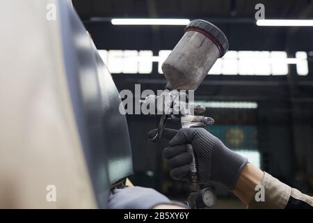 Auto service worker mano in guanto di protezione che tiene spay-gun verniciatura carrozzeria auto, orizzontale primo piano tiro, copia spazio Foto Stock