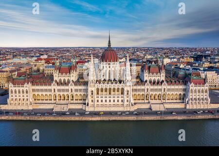 Budapest, Ungheria - veduta aerea del bellissimo palazzo del Parlamento ungherese con colori caldi al tramonto. Traffico pomeridiano, Danubio, trad Foto Stock
