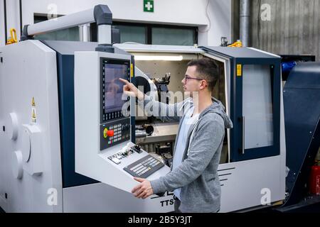 Remscheid, Renania Settentrionale-Vestfalia, Germania - apprendista nelle professioni del metallo, qui in una macchina utensile CNC, centro di formazione professionale del Remscheid Foto Stock