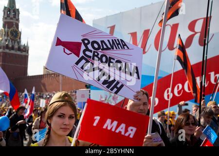 Mosca, Russia. 1st maggio 2014. Una giovane donna tiene la bandiera con l'iscrizione 'Terra, libertà, Putin' durante la marcia dell'Unione del lavoro dedicata alla Giornata della solidarietà Internazionale Dei Lavoratori e la Giornata della Primavera e del lavoro sulla Piazza Rossa a Mosca, Russia Foto Stock