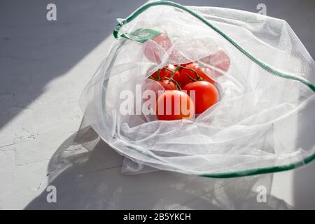 Pomodori in una borsa riutilizzabile su fondo in cemento. Concetto di zero sprechi. Concetto senza plastica. Concetti di vita sani. Foto Stock