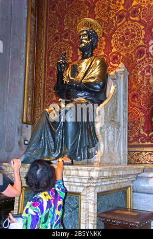 Italy.Rome.St.Peter's Cathedral.Bronze statua (XIII secolo) di San Pietro.attribuita ad Arnolfo di Cambo. Pellegrini toccare o baciare le dita del piede con riverenza. Foto Stock