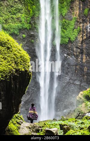 Vista mozzafiato di un turista che gode della vista delle cascate Tumpak Sewu. Indonesia. Foto Stock