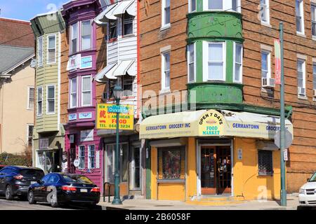 Un angolo colorato di Germantown con case a schiera e un negozio ad angolo all'incrocio tra Duval St, e Germantown Avenue, Philadelphia, PA. Foto Stock