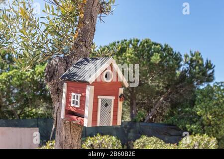 Little Birdhouse over wooden table outdoors in the garden Foto Stock