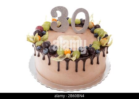 Torta di compleanno al cioccolato per un uomo. Su sfondo bianco con frutti di bosco. Foto Stock