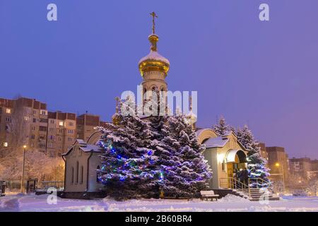 Donetsk, Ucraina. 7 gennaio 2020. Chiesa di San Benedetto Xenia di Petersburg.Snowy inverno, pre-alba time.Parishioners in piedi sul portico durante il Foto Stock