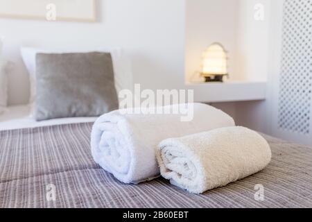 Asciugamani bianchi sul letto in camera da letto. Primo piano Foto Stock