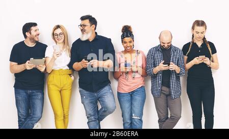 Gruppo multiculturale di amici addicted ai telefoni cellulari intelligenti – concetto di diversità con persone multirazziali che si divertono Foto Stock