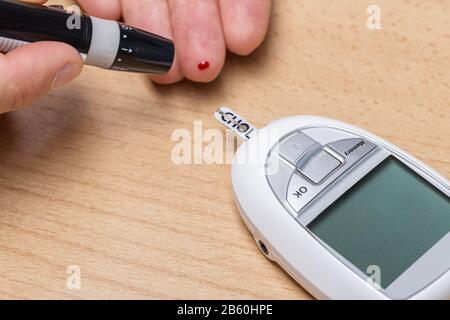 Dispositivo per la misurazione del colesterolo, dell'insulina e dello scarificatore . Esame del sangue. Foto Stock