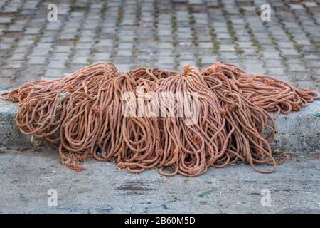 Un mucchio di funi su asfalto per le reti di pescatori. Foto Stock