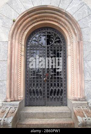 porta ad arco in ferro battuto con decorazioni floreali e cornice in alabastro Foto Stock