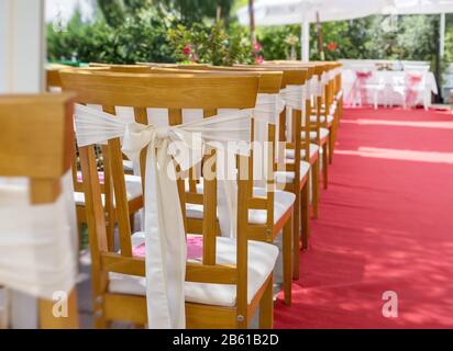 Outdoor nozze con tappeto rosso petali di fiore bianco coperto sedie e una  romantica arch Foto stock - Alamy