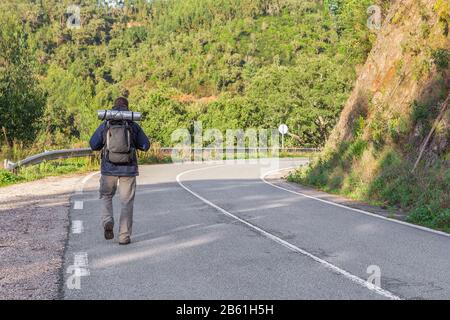 Il ragazzo sportivo va in campeggio. In autostrada. Foto Stock