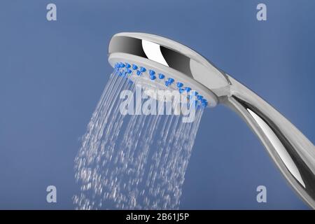 L'acqua si riversa fuori dalla doccia, su uno sfondo blu. Foto Stock