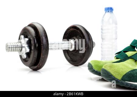 Dumbbell, una bottiglia di acqua pura sullo sfondo e scarpe da running per atletica. Foto Stock