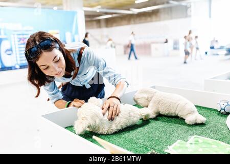 Donna giocare con robot terapeutico cute PET giocattolo per disabili Foto Stock