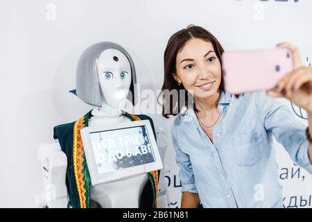Ultra MALL, UFA, RUSSIA, 21 AGOSTO 2017: Ragazza positiva che fa selfie con robot alla mostra, concetto di istruzione Foto Stock