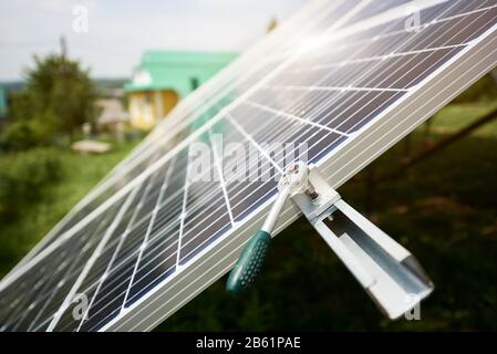 Concetto alternativo di energia solare. Stazione pannelli solari vicino alla casa con chiave su sfondo cielo. Concetto di ecologia. Contesto scientifico. Concetto alternativo di energia solare. Foto Stock