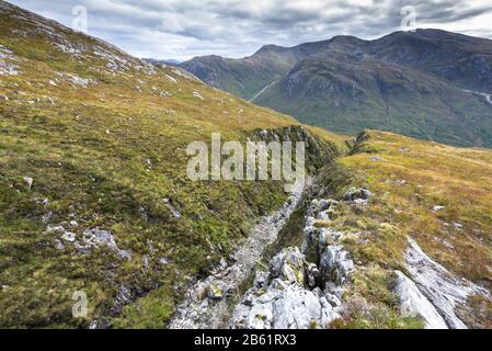 River bed of the Allt à Chait correre in una linea di faglia, con le montagne di Kingairloch in lontananza, Scozia Foto Stock