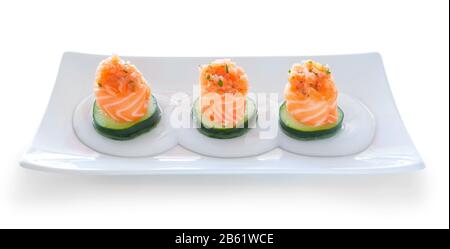 Tre porzioni di salmone al sushi e ripieno di cetrioli. Su un piatto. Foto Stock