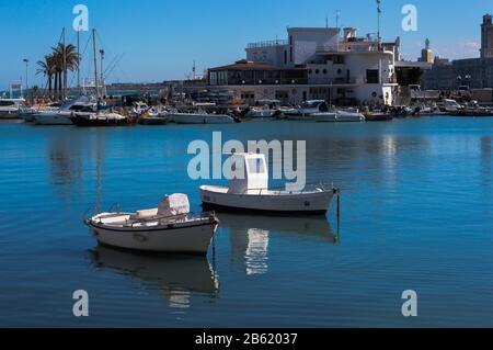 Bari, ITALIA - 16 FEBBRAIO 2020: Due piccole imbarcazioni in acque calme sullo sfondo del molo di Bari nel porto di pesca in Puglia Foto Stock