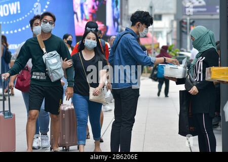 Kuala Lumpur, Malesia. 9th Mar, 2020. Le persone che indossano maschere camminano su una strada a Kuala Lumpur, Malesia, 9 marzo 2020. La Malaysia ha annunciato lunedì 18 nuovi casi di COVID-19, portando il numero totale di casi a 117. Credit: Chong Voon Chung/Xinhua/Alamy Live News Foto Stock