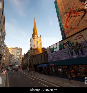 Bristol, Inghilterra, Regno Unito - 29 dicembre 2019: Il sole serale splende sulla guglia della Chiesa di San Giovanni e dei moderni edifici alti su Nelson Street nella c Foto Stock