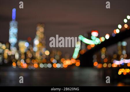 Luci sfocate del Ponte di Brooklyn e di New York City Manhattan. Vista notturna Foto Stock