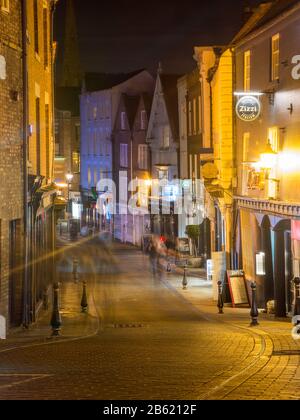 Durham, Inghilterra, Regno Unito - 29 gennaio 2017: I pedoni passano davanti ai negozi e ai ristoranti di Saddler Street a Durham di notte. Foto Stock