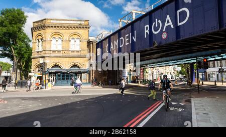 Londra, Inghilterra, Regno Unito - 21 giugno 2016: Pedoni e ciclisti passano attraverso l'incrocio tra Camden Road e Royal College Street, sotto il London Ov Foto Stock