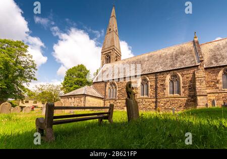 Bamford, England, Regno Unito - 19 Maggio 2011: il sole splende sulla guglia e il cimitero della Chiesa di San Giovanni Evangelista a Bamford in inglese il Peak District. Foto Stock