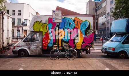 Londra, Inghilterra, Regno Unito - 4 luglio 2010: Un furgone scruffy dipinto con graffiti è usato dai commercianti di mercato per immagazzinare sul mercato di Whitechapel nell'Est e di Londra Foto Stock