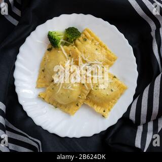 ravioli di ricotta e spinaci su tessuto nero Foto Stock