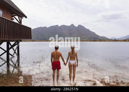 Coppia caucasica pronta a nuotare nel lago vicino alla capanna di legno Foto Stock