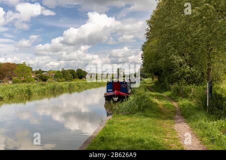 Le barche sul canale ormeggiate lungo il canale Kennet e Avon nel mese di giugno a Great Bedwyn, Wiltshire, Inghilterra, UK Foto Stock