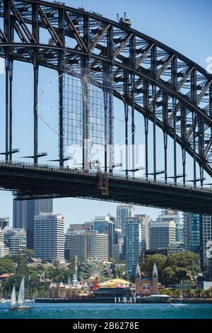 Il Sydney Harbour Bridge con Luna Park e lo skyline della città di Sydney fanno da sfondo a una giornata di sole Foto Stock