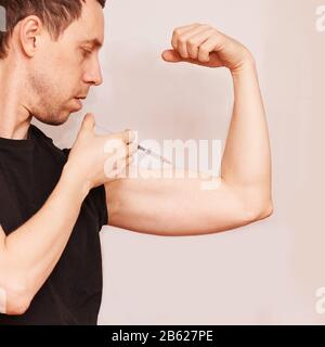 L'uomo inietta l'ormone steroide. Procedura di iniezione della crescita Foto Stock