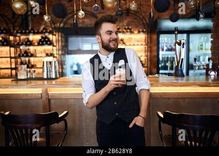 giovane e piacevole barista che si diverte al lavoro, close up photo. entertainmnet, felicità, sensazione positiva ed emozione Foto Stock