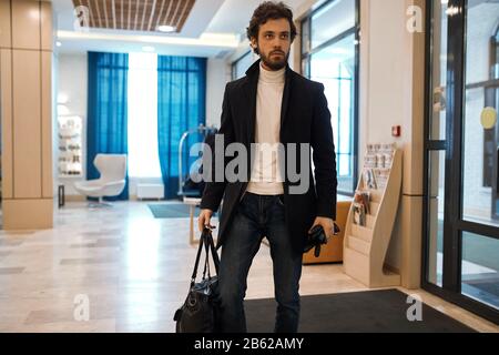 buon uomo sicuro nel modo abbigliamento casual pubblicità borsa, guanti, vendita, sconto, stile concetto. primo piano foto Foto Stock