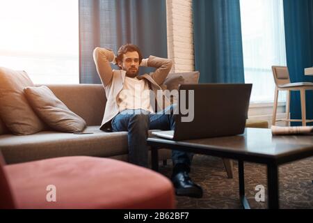 giovane uomo rilassato che riposa sul divano, guardando film, film, foto da vicino. weekend, giorno fuori, tempo libero, tempo libero, stile di vita Foto Stock