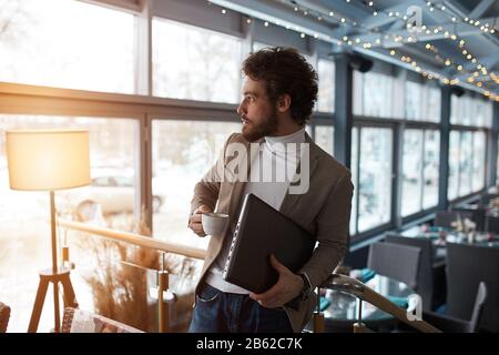 giovane uomo d'affari che ha colazione nel caffè, primo piano vista laterale foto Foto Stock