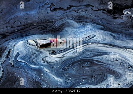 Bottiglia di Coca-cola galleggiante in acqua inquinata, Barcellona, Spagna. Foto Stock