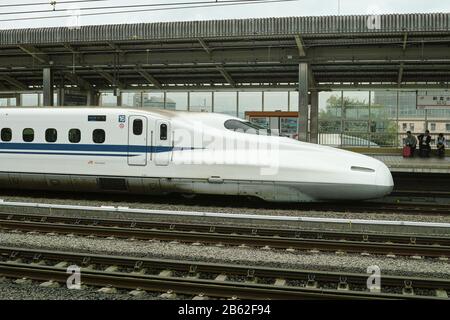 Yamanasi, Giappone - 27 6 201: L'iconico Shinkansen che entra in una stazione più locale Foto Stock